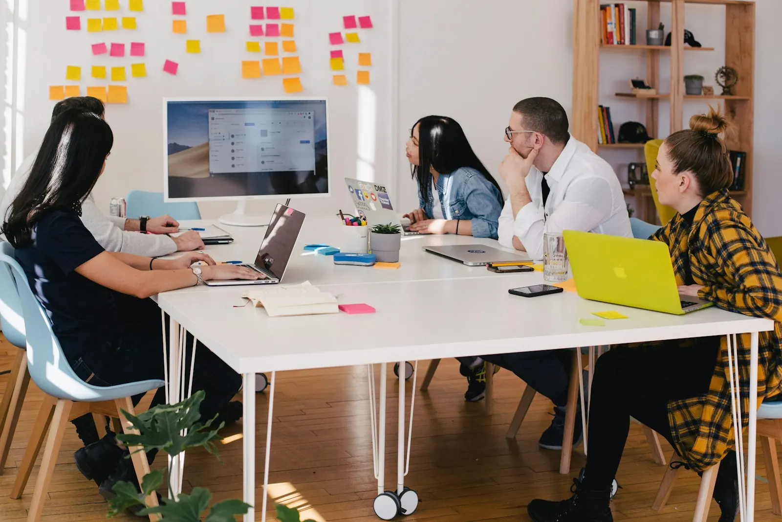 A marketing team working together around a table with laptops