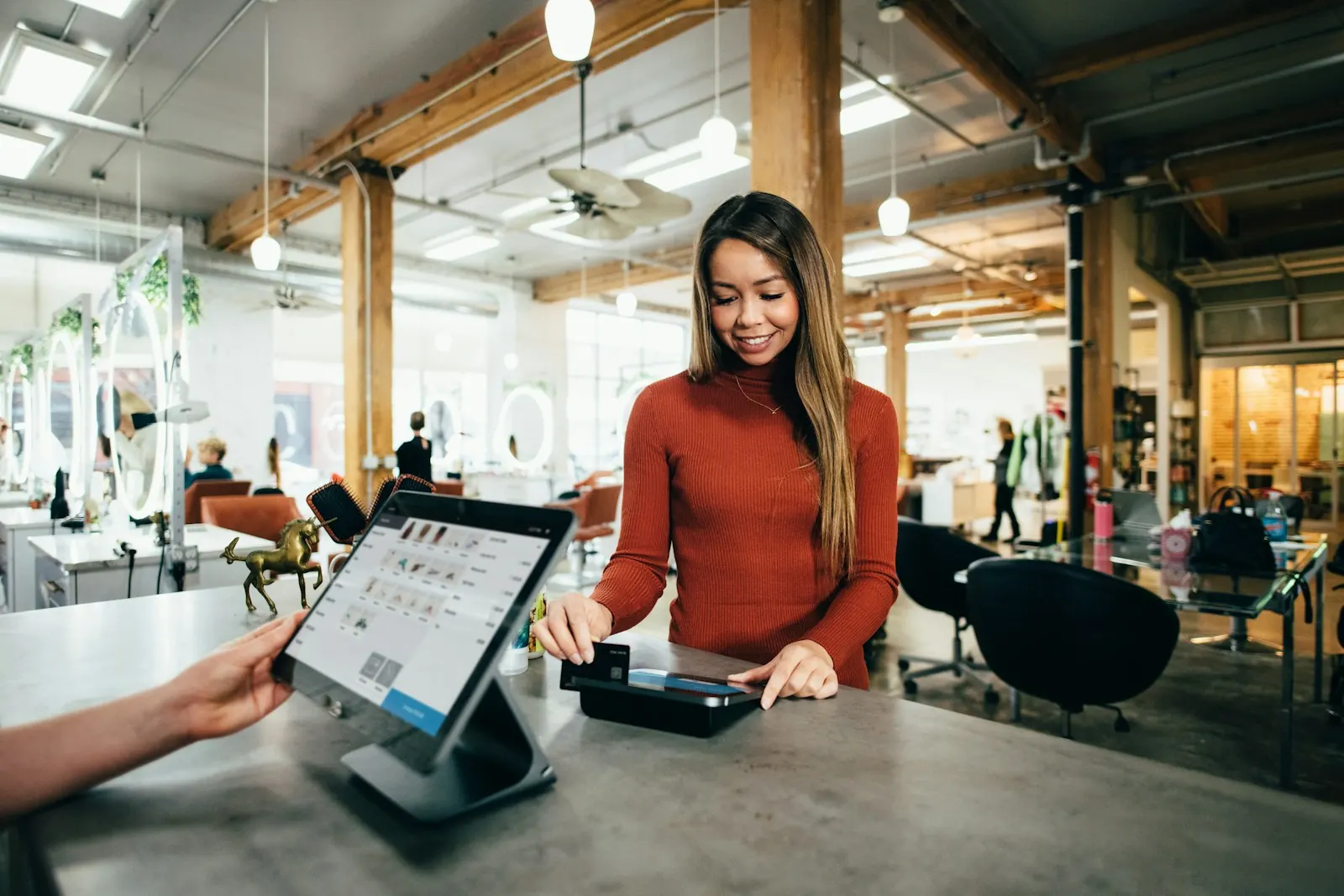 A store owner taking an order on a tablet at a bright shop counter