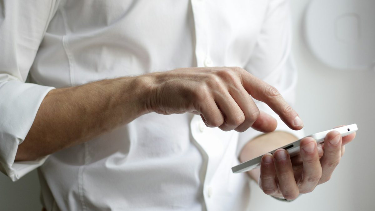 A professional reading a business text message on a smartphone