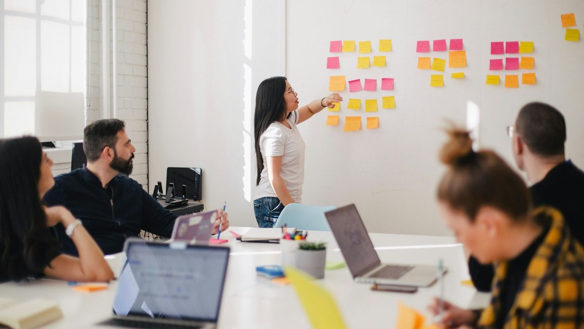 A team planning a customer journey at a whiteboard covered in sticky notes